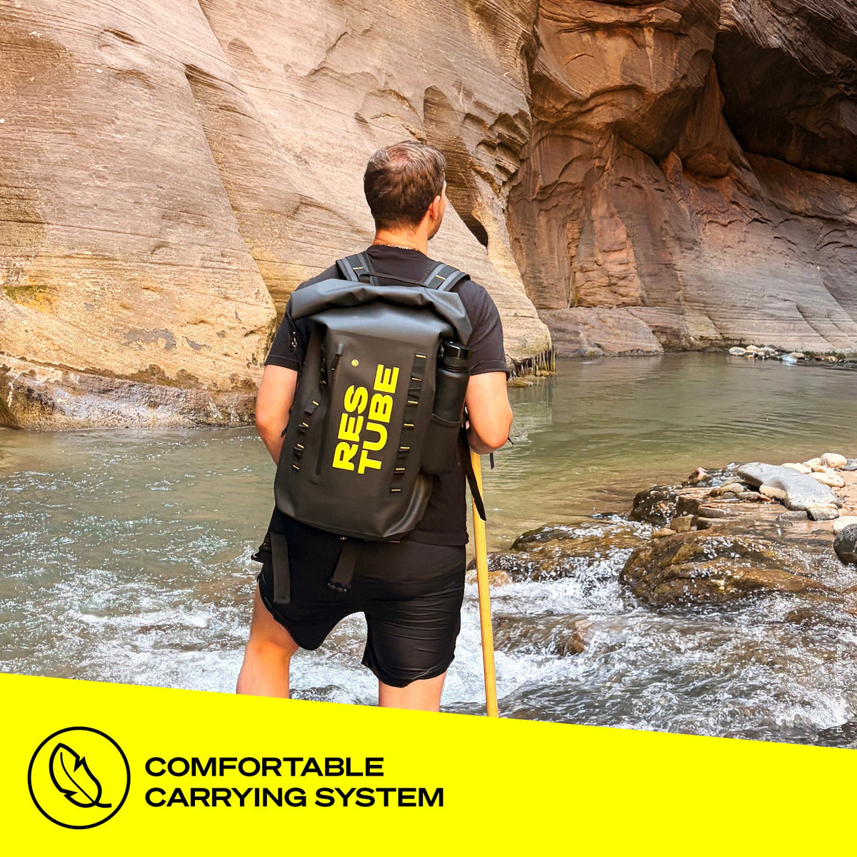 Man at rocky river with RESTUBE COAST 25L black backpack showing comfortable carrying system padded shoulder straps Philippines