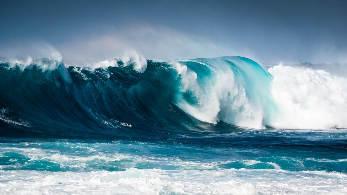 Powerful breaking surf wave with white foam and spray