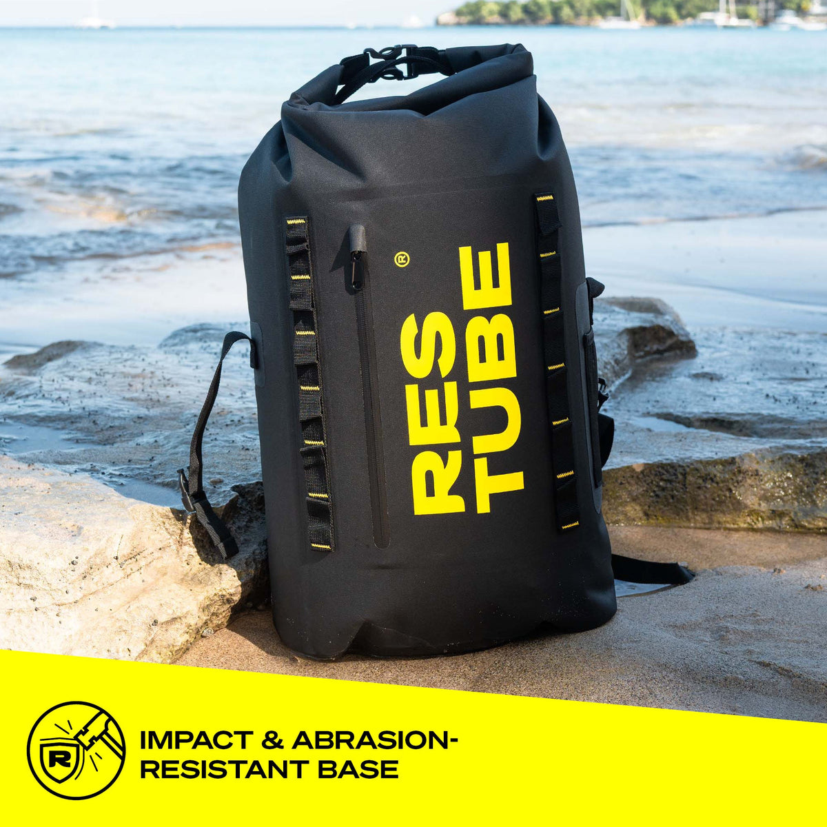 RESTUBE COAST 25L black backpack on rocks by the ocean - impact-resistant abrasion-proof base Philippines